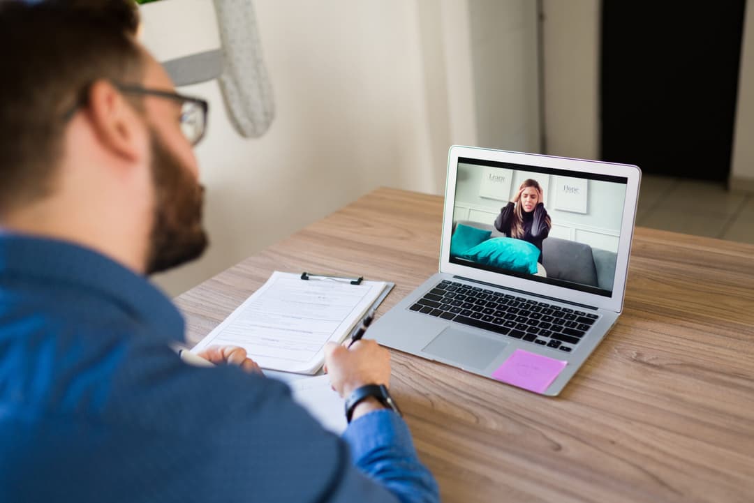 Virtual therapy. Depressed woman with mental health problems speaking to her psychiatrist during an online video call